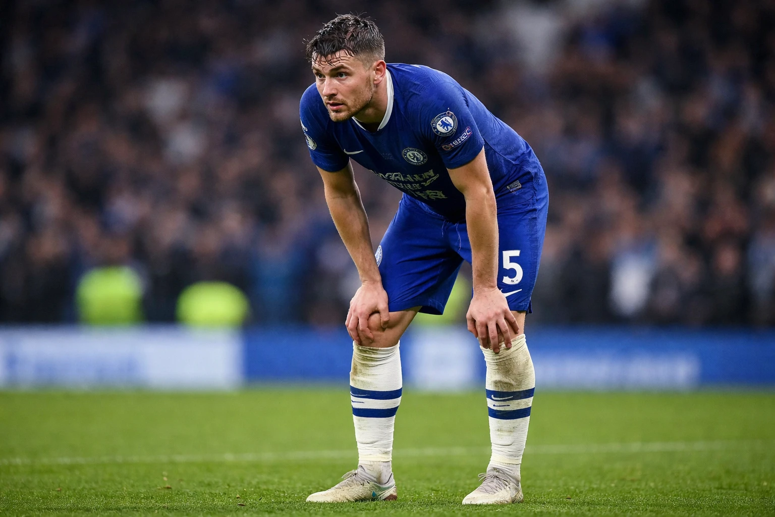 Football player showing signs of tiredness during a match, hands on knees
